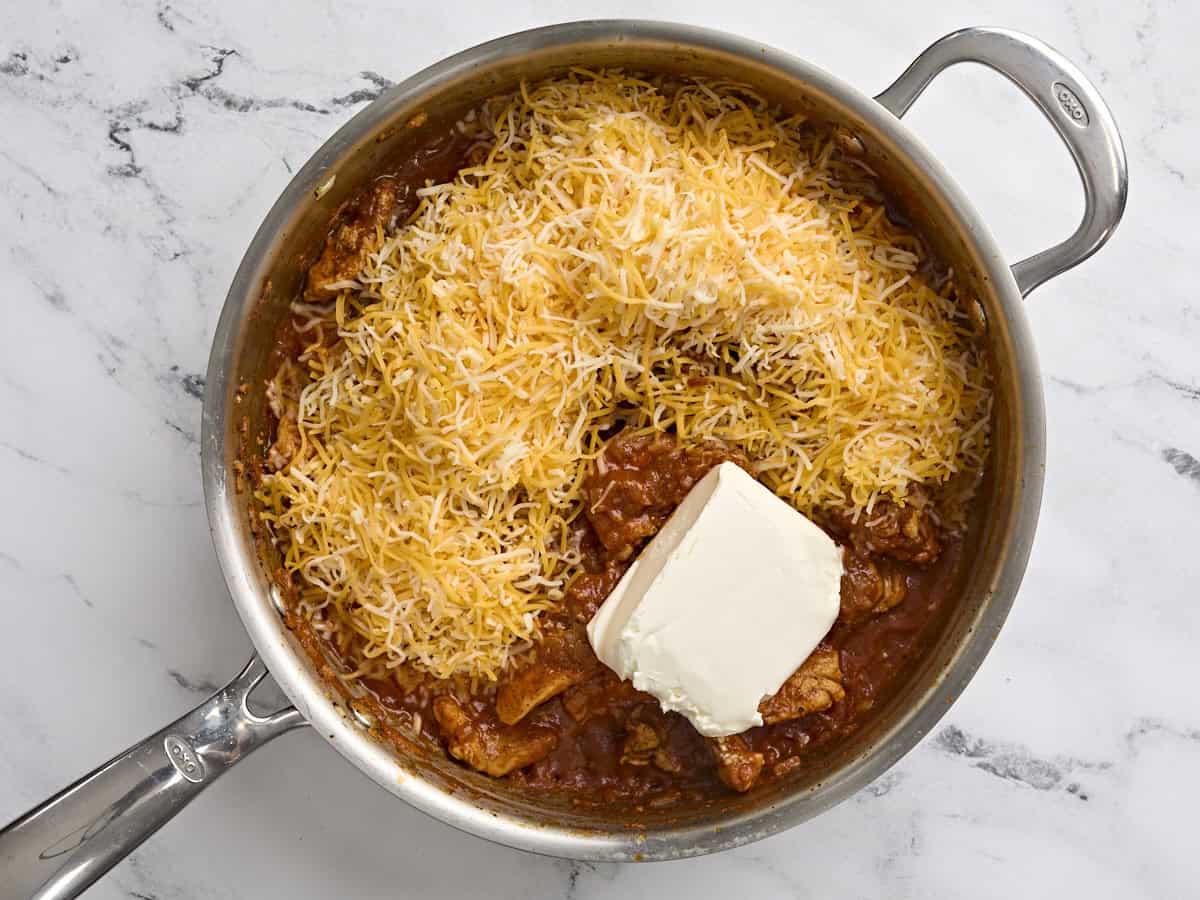 El queso crema y el jack rallado de Colby se sumaron a una sartén con salsa de pollo y tomate sazonadas.