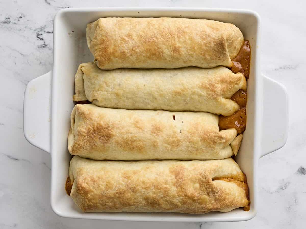 Chimichangas de pollo horneado terminado en una fuente para hornear.