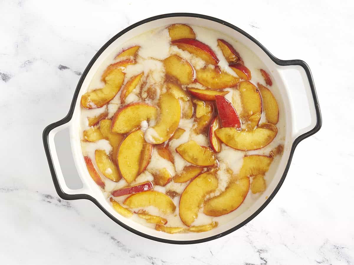 La mezcla de durazno se agregó a la masa para zapatero en un plato de horno.