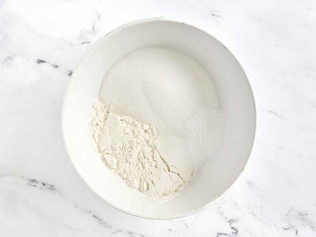 Harina, polvo de hornear, sal y azúcar granulada en un tazón de mezcla.