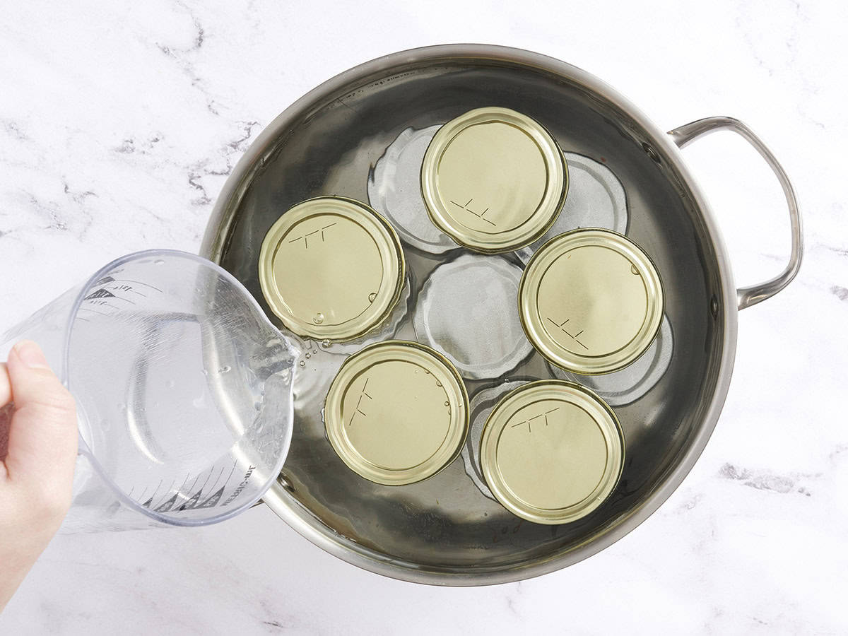 El agua que se vierte en una cacerola de calabacín de sabor a los frascos.