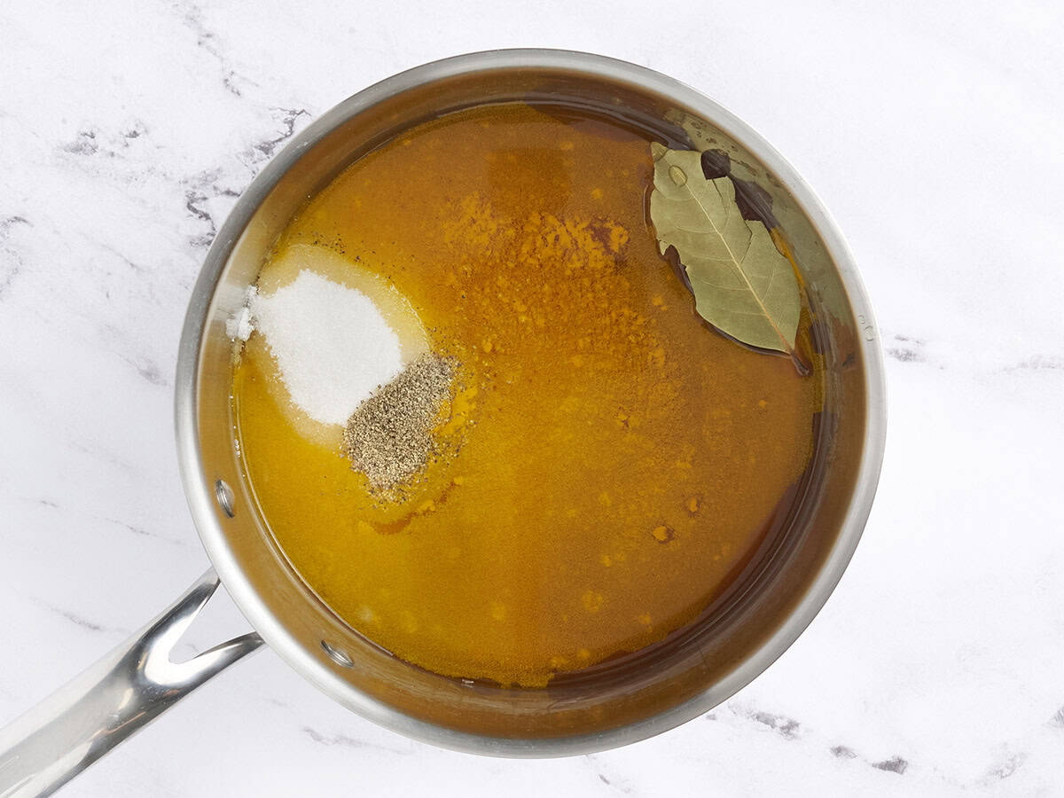 Vinagre, azúcar y especias en una cacerola para hacer líquido de encurtido.