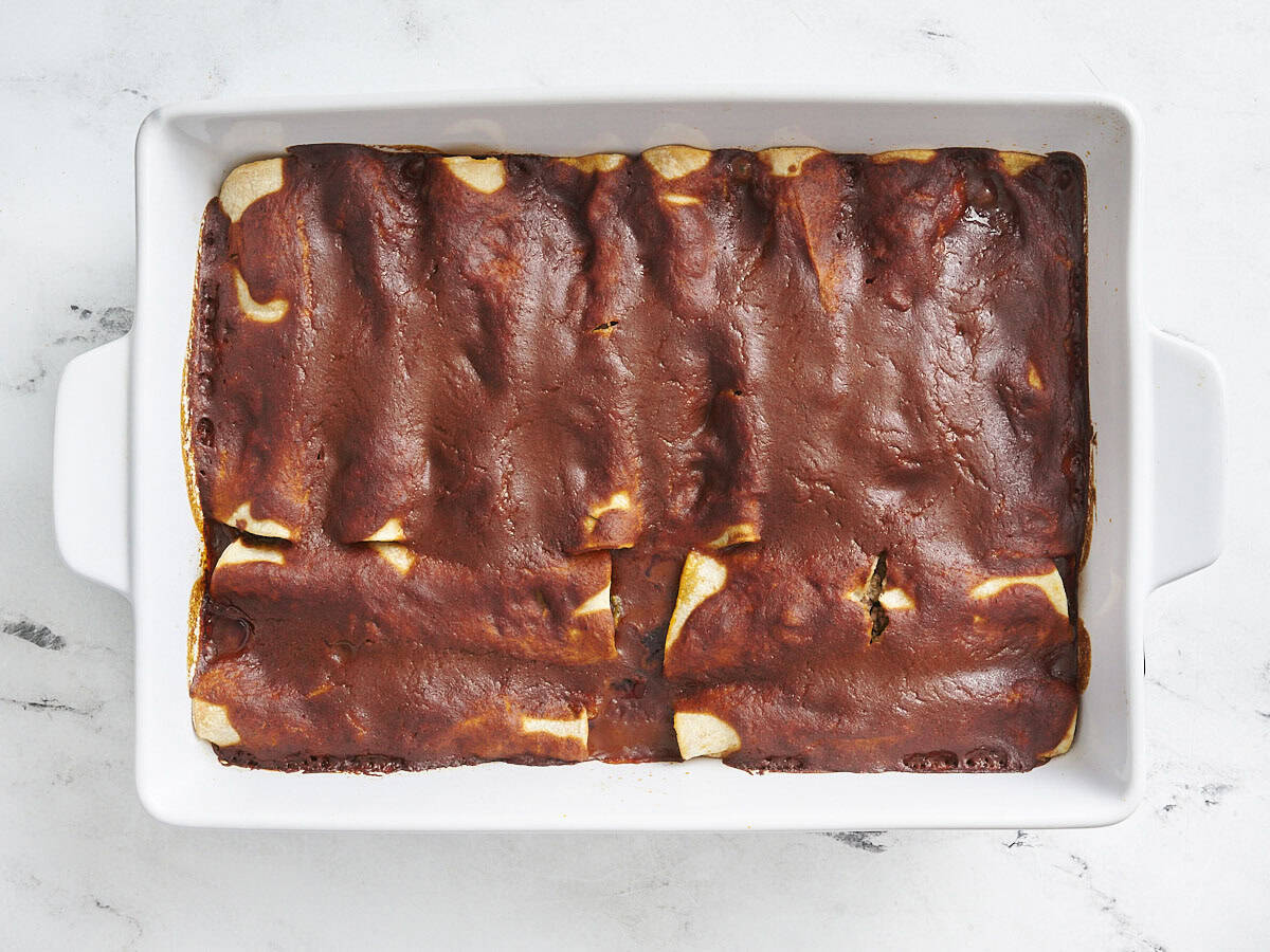 Enciladas de carne horneada en una fuente para hornear.