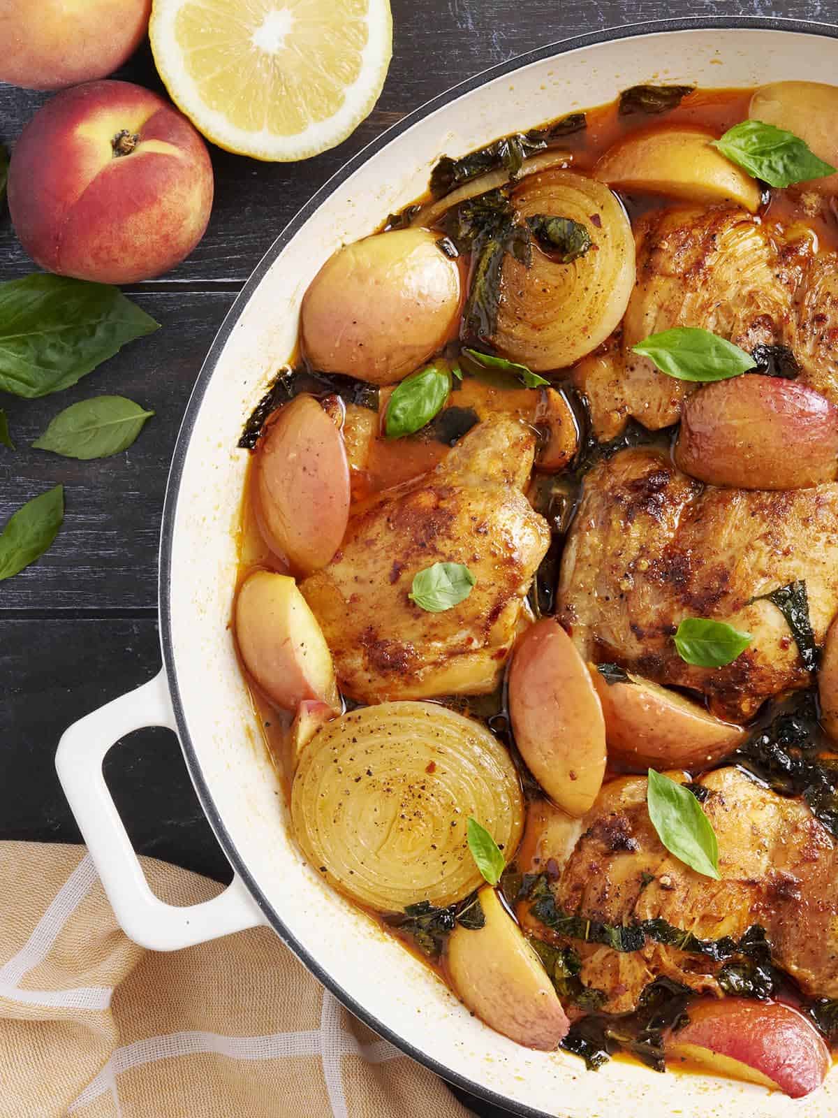 Alterna de pollo estofado y duraznos en una sartén.