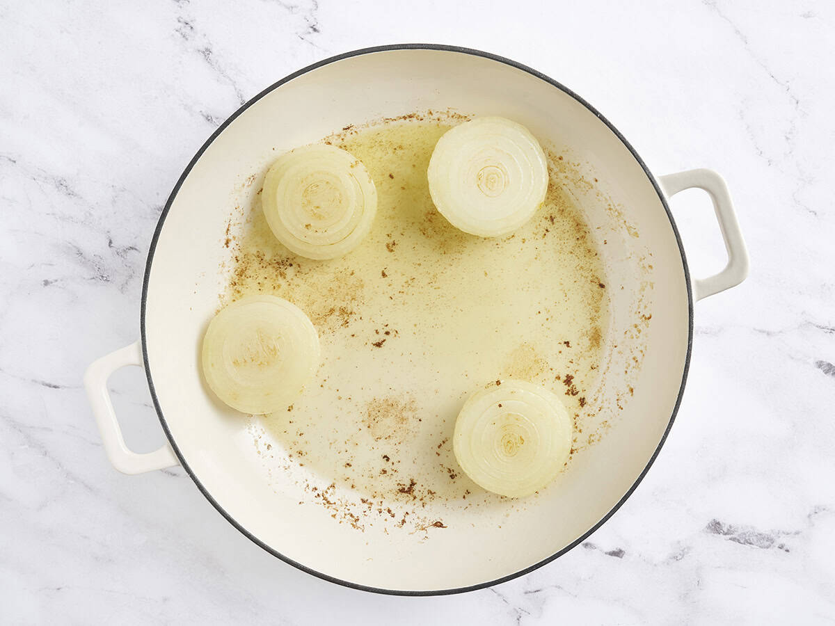 Las mitades de la cebolla se doran en una sartén.