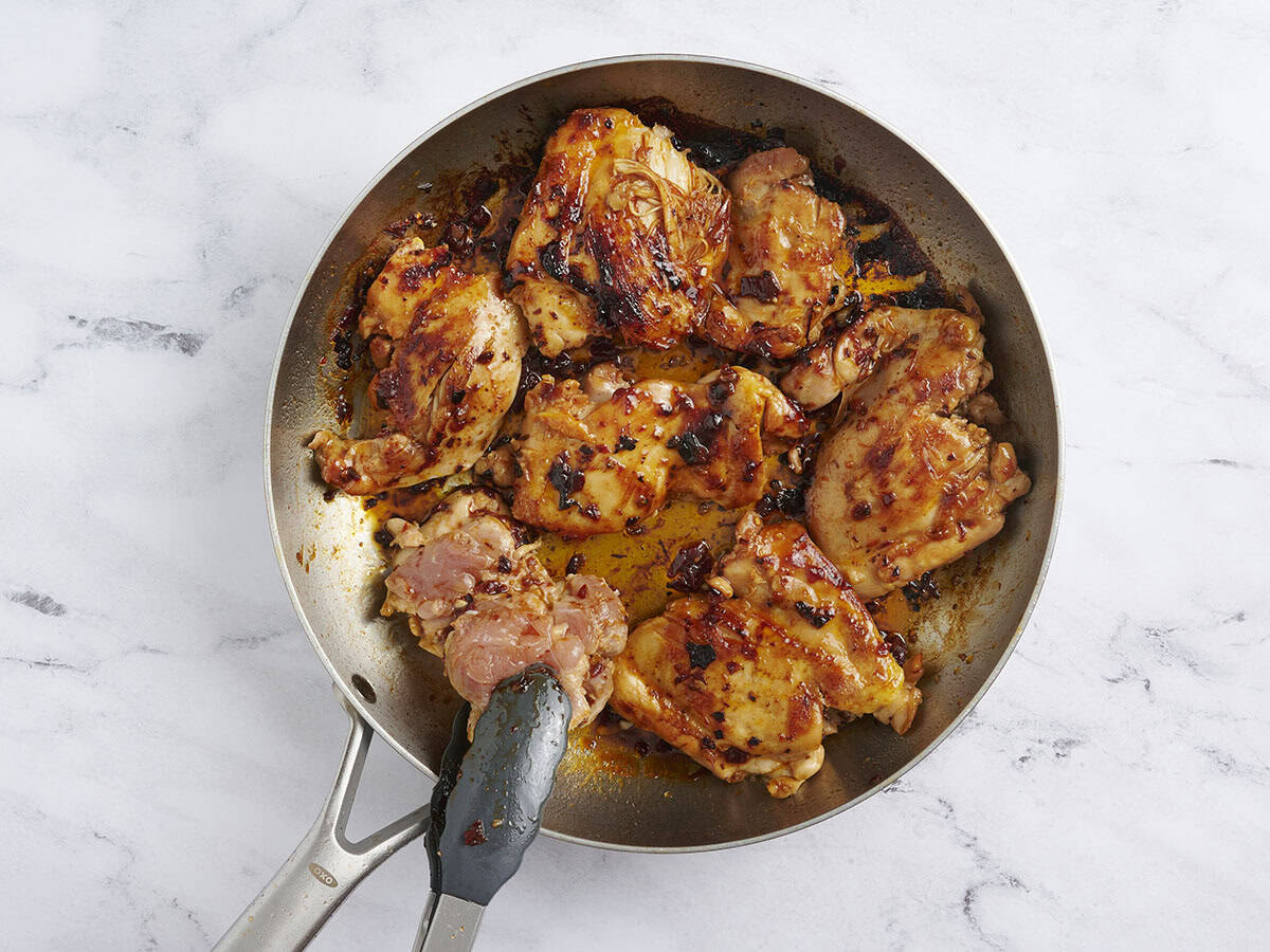 Cocina Tinks volteando pollo con miel chipotle en una sartén.