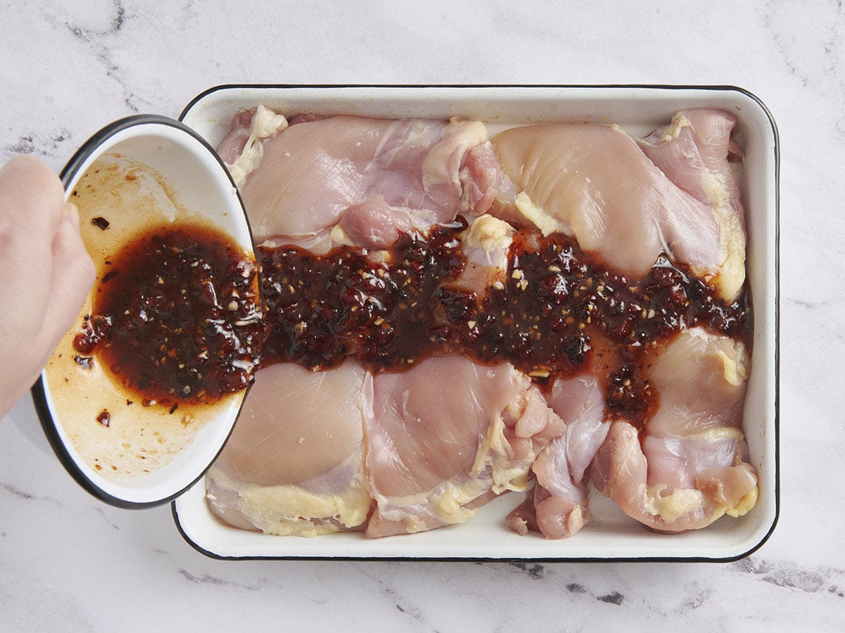 Una marinada de miel Chipotle se vierte sobre muslos de pollo deshuesados ​​y sin piel.