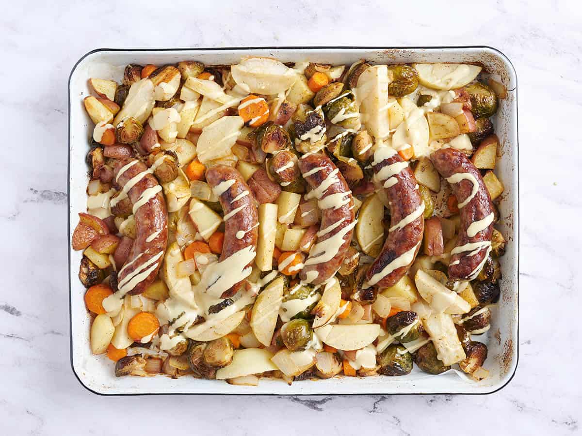 La sartén del Oktoberfest rociaron los mocosos con salsa de mostaza en una bandeja para hornear.