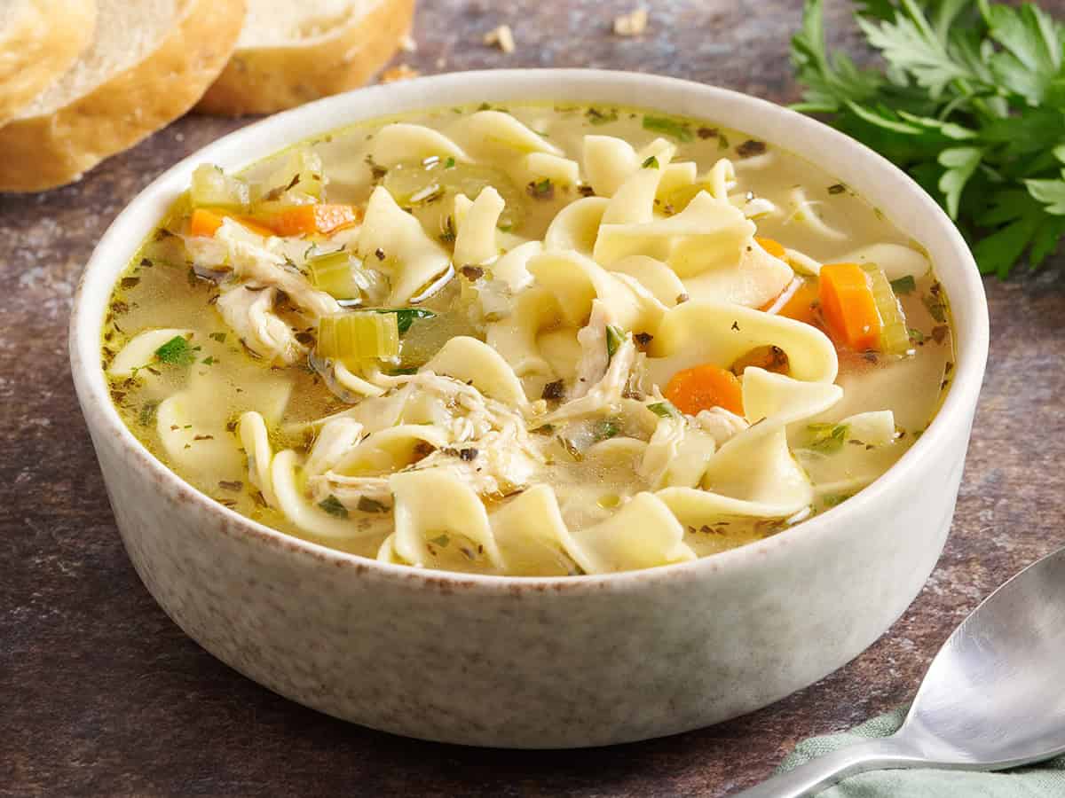 Vista lateral de un tazón de sopa de fideos de pollo.