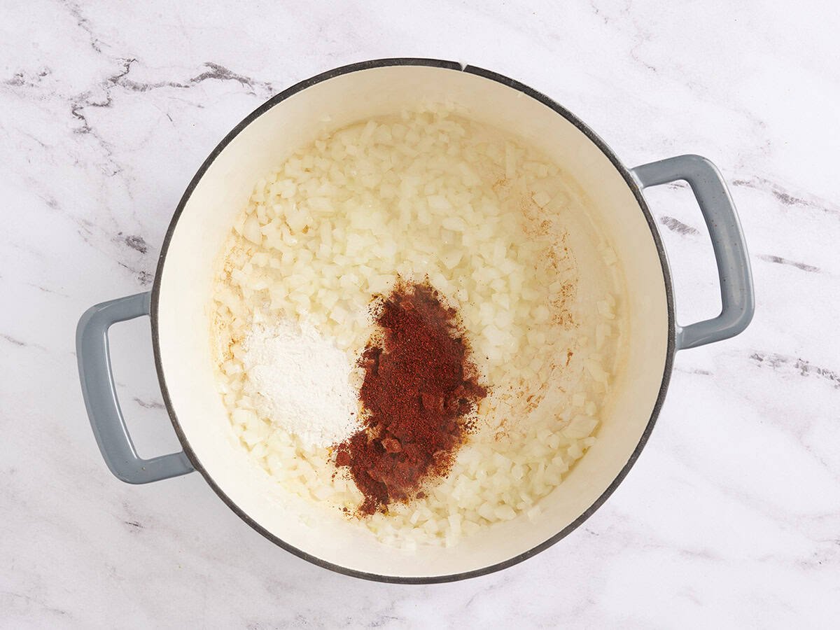Se agrega harina y chile en polvo a la cebolla salteada picada.