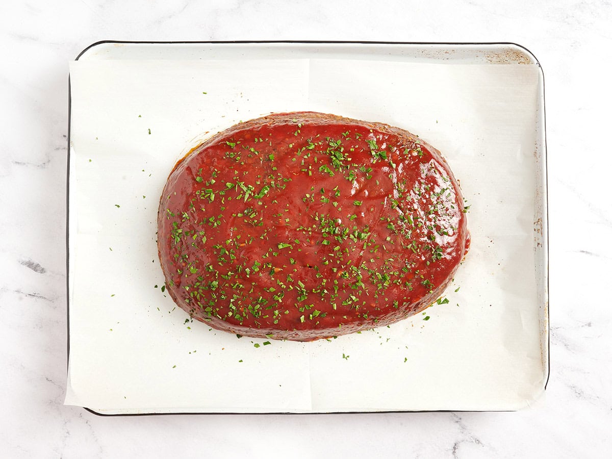 Un pan de lentejas terminado en una bandeja para hornear forrada con pergamino después de hornearlo.