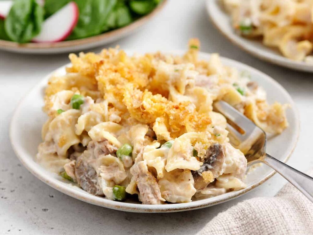 Side view of a plate of tuna noodle casserole with a fork.