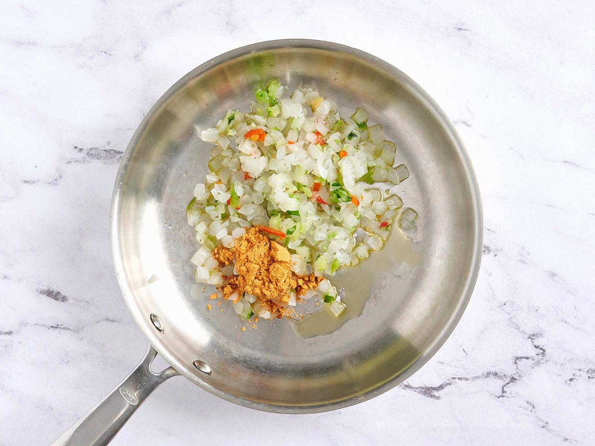 Verduras mixtas congeladas y condimento para tacos en una sartén.