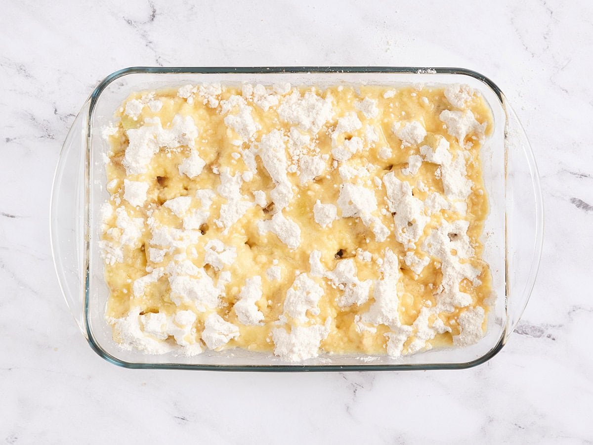 Un pastel de manzana en una fuente para horno antes de hornearlo.