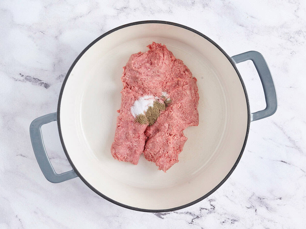 Carne molida y condimentos en una olla.