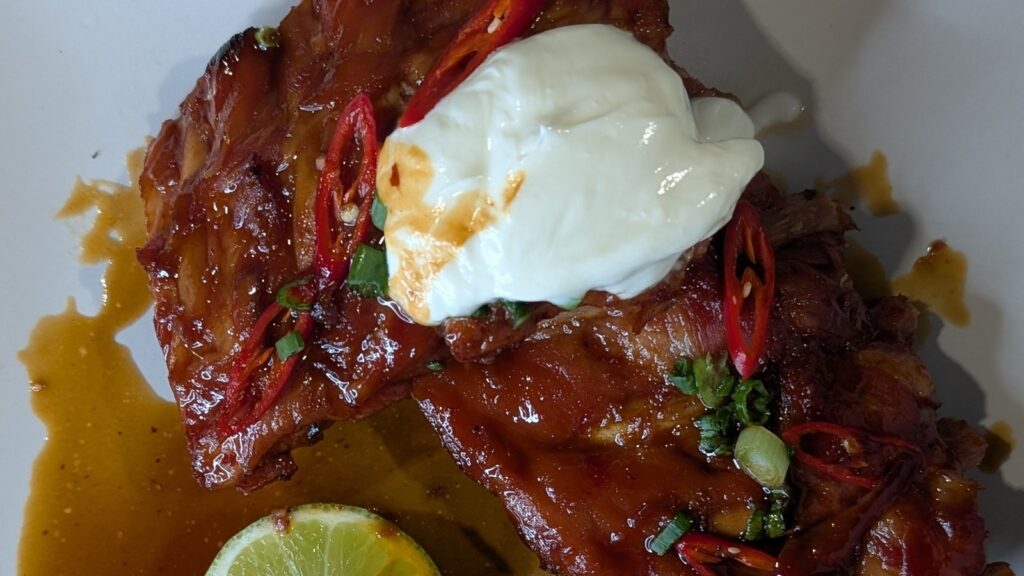 Costillas de tocino glaseadas con miel y chile de Derry, ensalada de repollo verde y yogur de cebollino