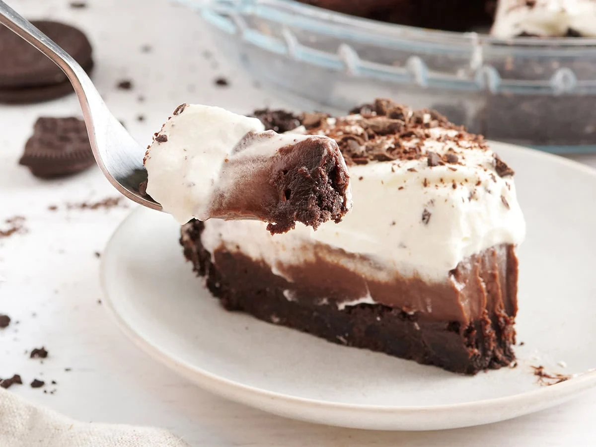 Vista lateral de una rebanada de Mississippi Mud Pie con un tenedor tomando un poco.