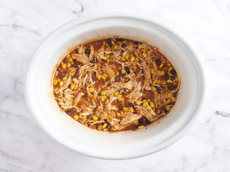 Tazones para tacos en olla de cocción lenta en una olla blanca.