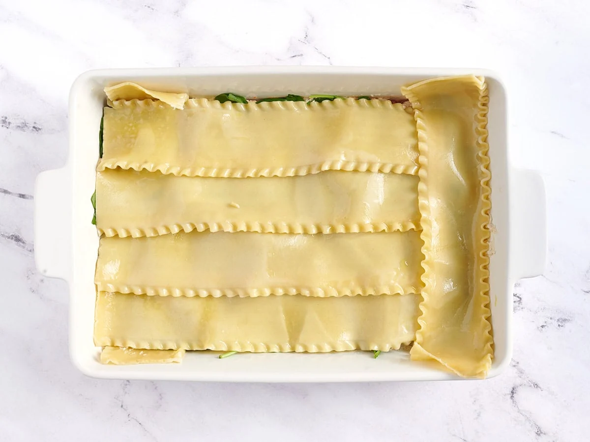 Fideos de lasaña cocidos añadidos a la cazuela.