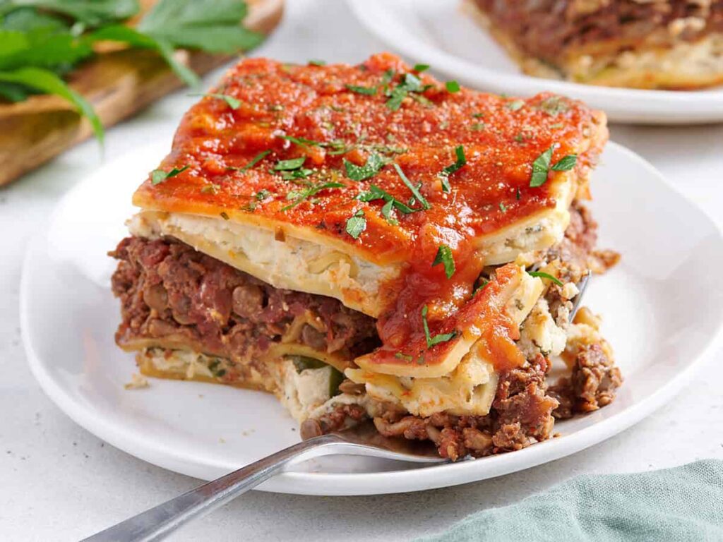 Side view of a slice of vegan lasagna with a fork.
