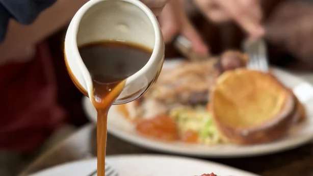 Fotografía de archivo de una cena dominical tradicional con suculento rosbif, cocinado a la perfección y servido con patatas asadas doradas y crujientes. Acompañada de esponjosos pudines de Yorkshire y un generoso chorrito de rica salsa, esta abundante comida se complementa con vibrante repollo al vapor y tiernas zanahorias.