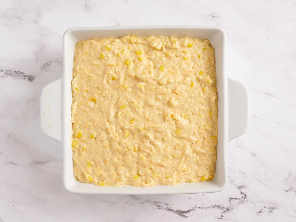Masa de pan de maíz en una fuente para horno blanca.