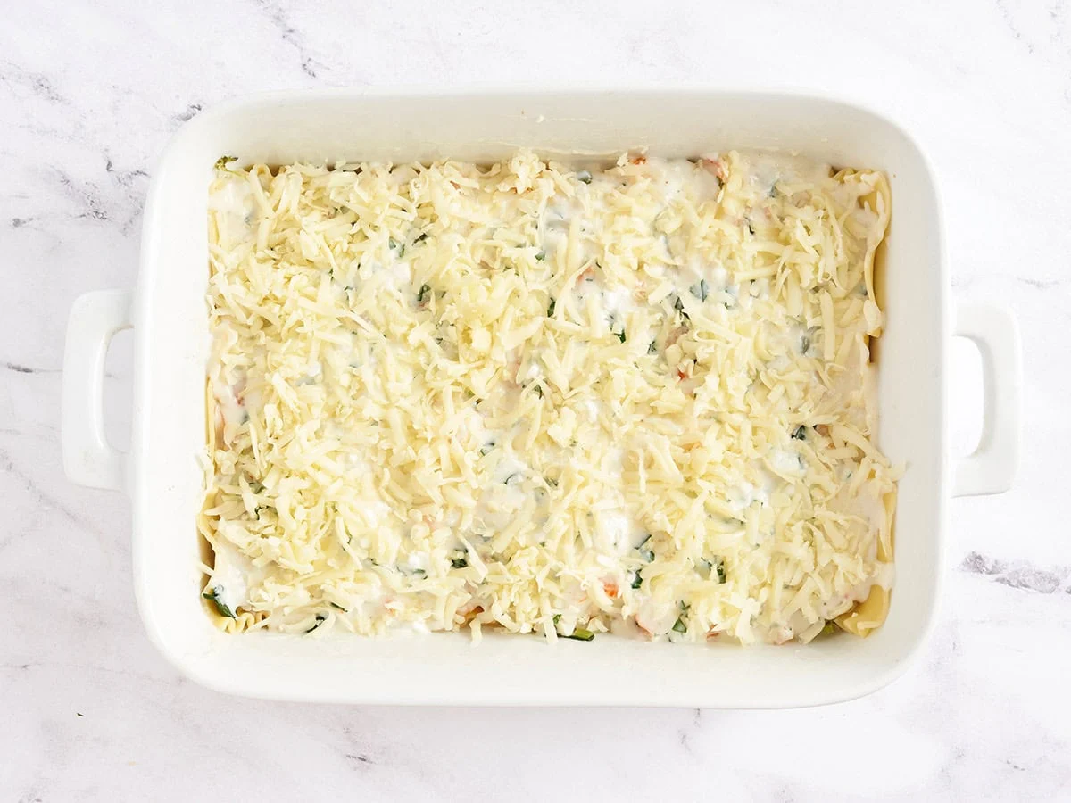 Una lasaña de mariscos cubierta con mozzarella.