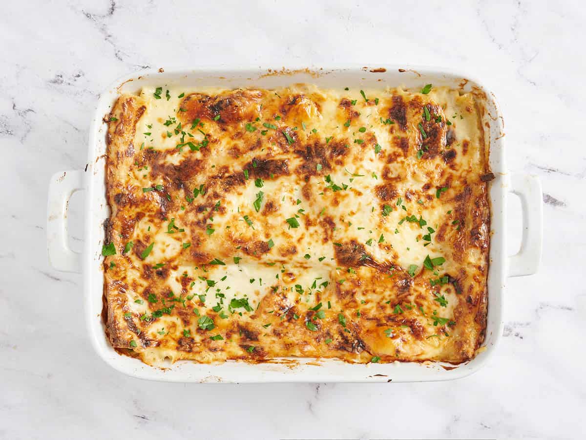 Lasaña de mariscos terminada cubierta con perejil.