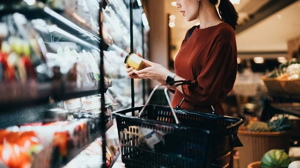   mujer en la tienda leyendo la etiqueta de los alimentos
