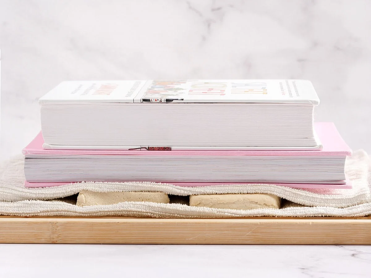 Tofu prensado con libros de cocina.