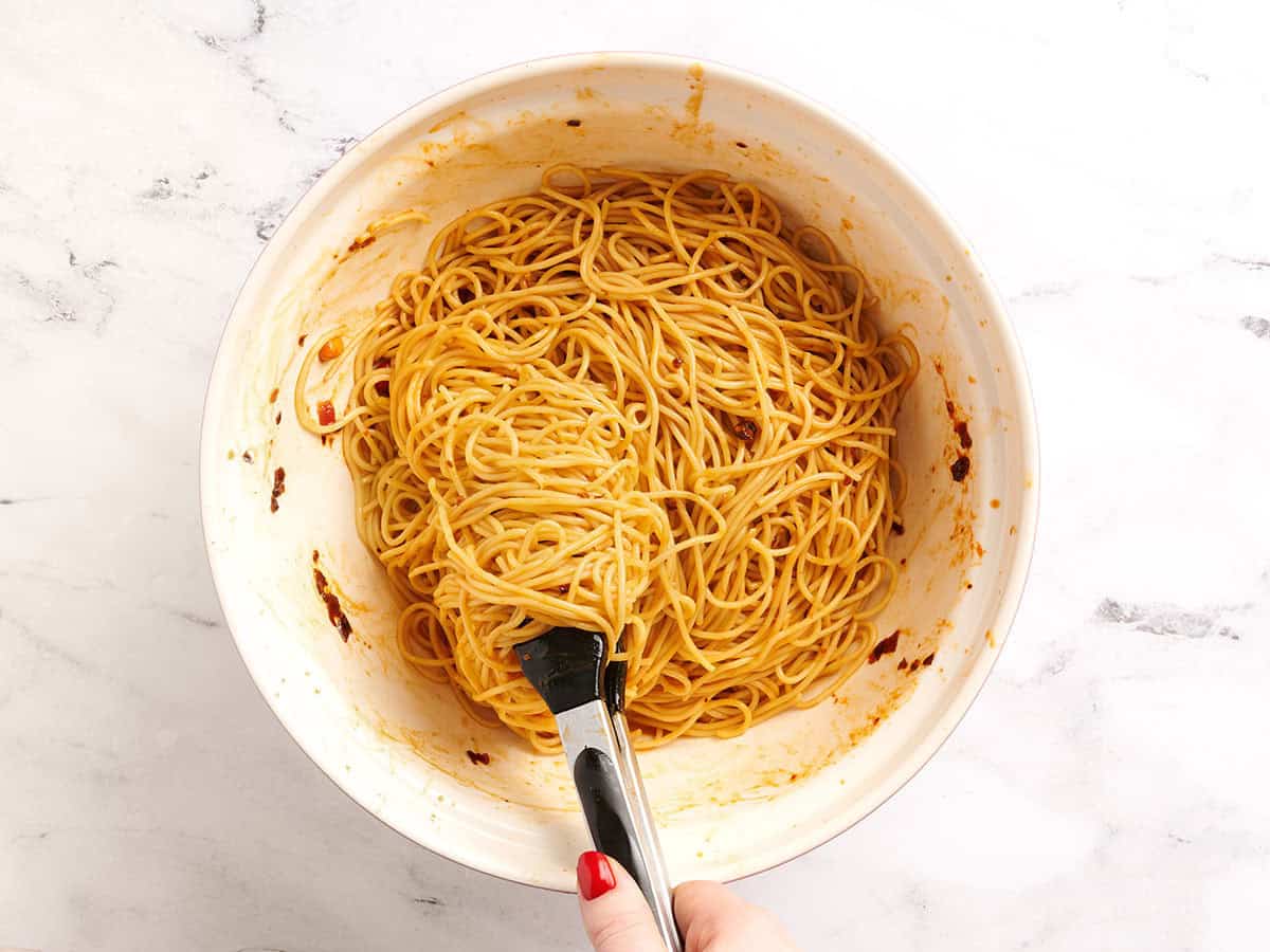 Fideos Dan Dan arrojados con salsa en un tazón.