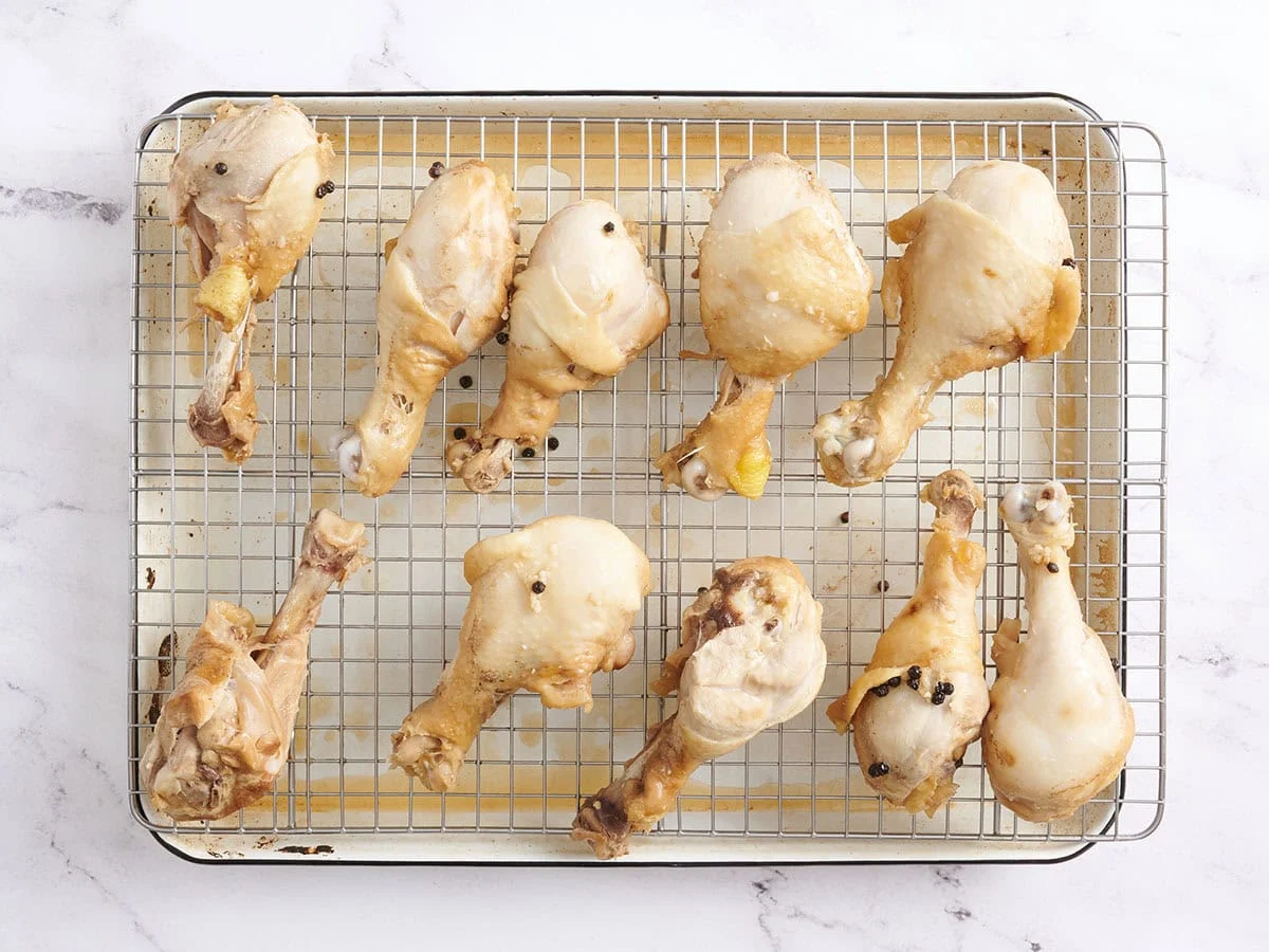 Muslos de pollo dorados sobre una rejilla colocada sobre una bandeja para hornear