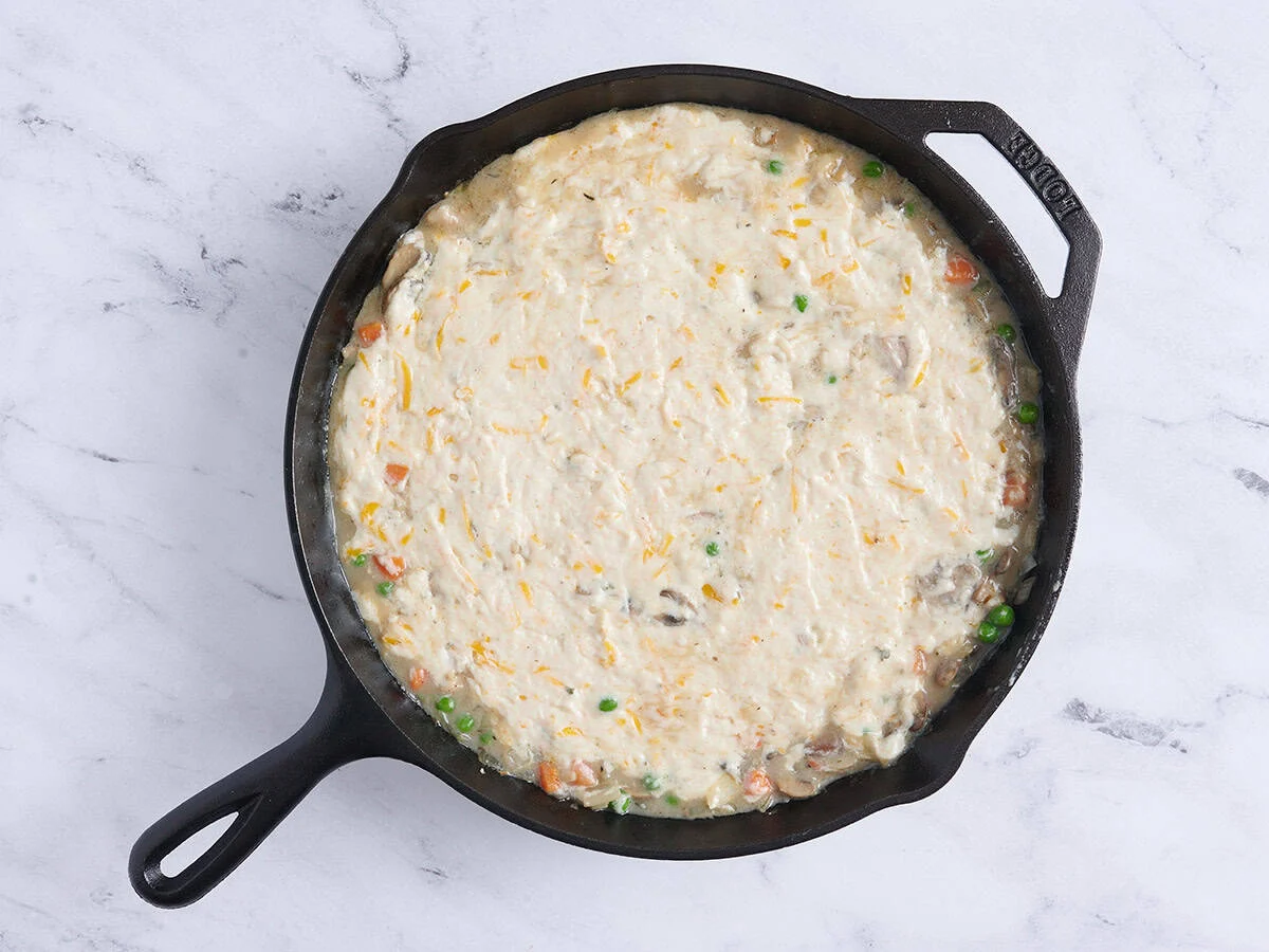 Pastel de pollo en una sartén antes de hornear.