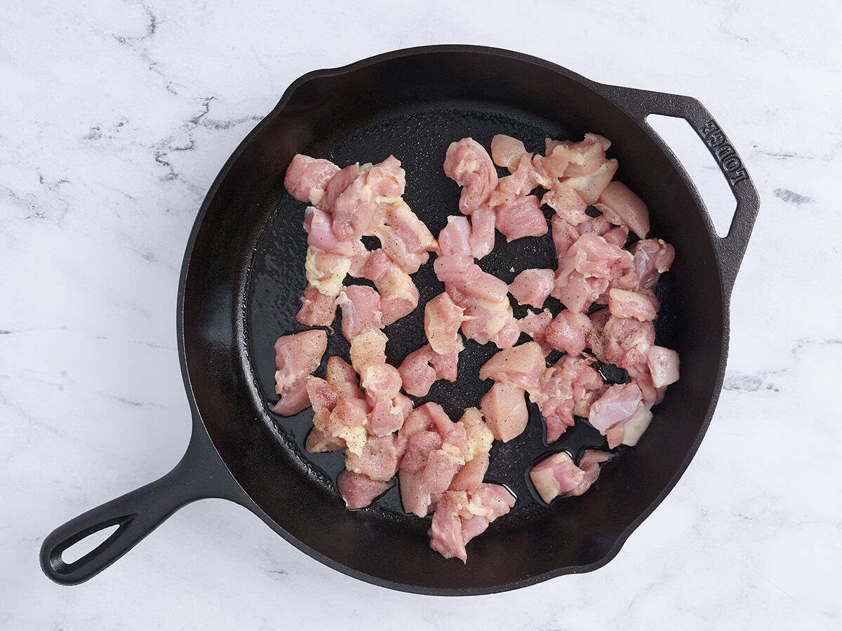 Trozos de muslo de pollo cocinados en una sartén.