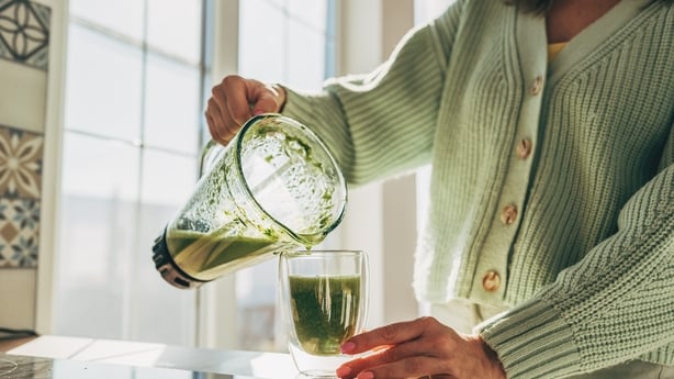 Mujer joven haciendo batido detox 