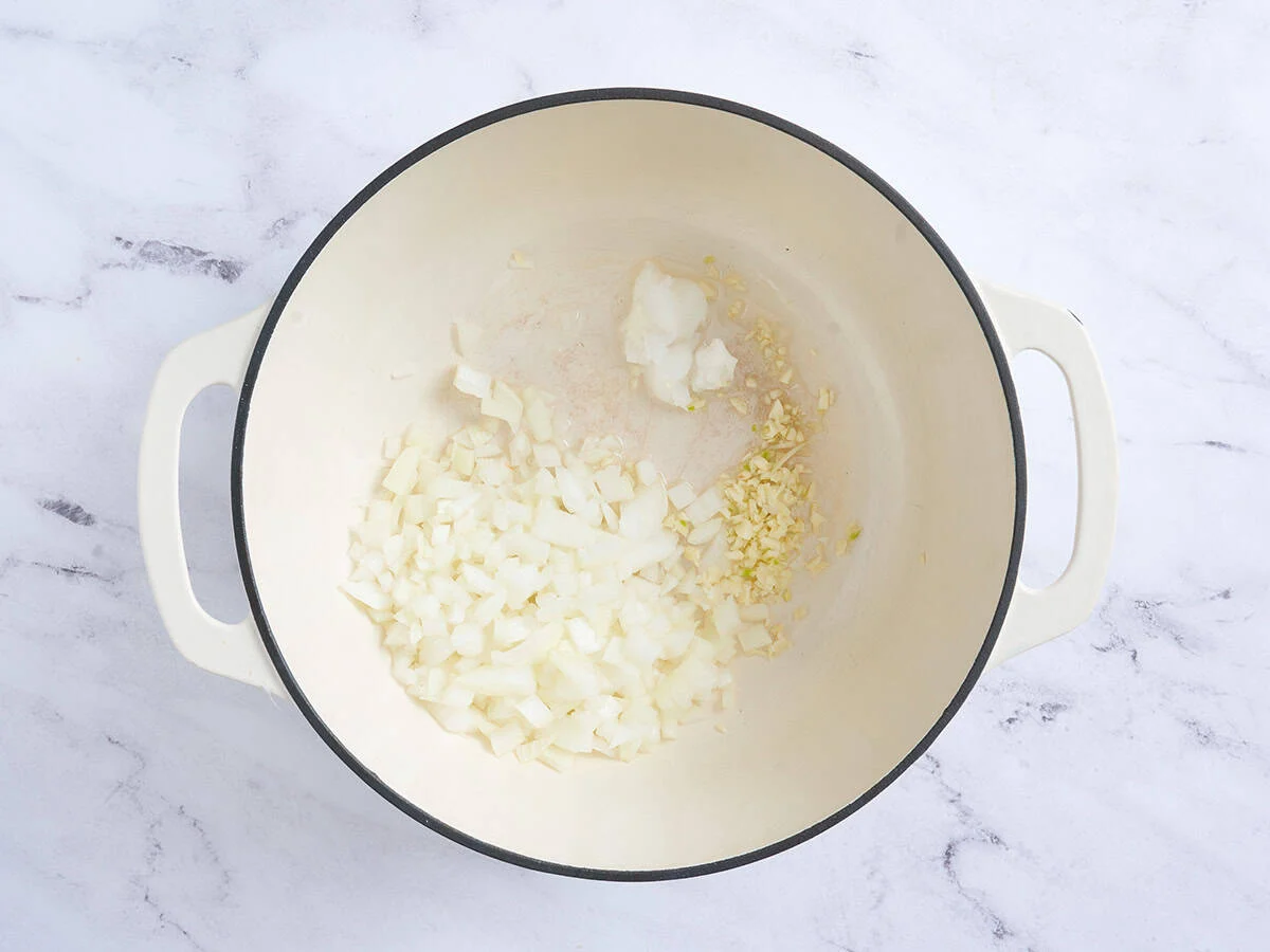 Cebolla y ajo salteando en una sartén.