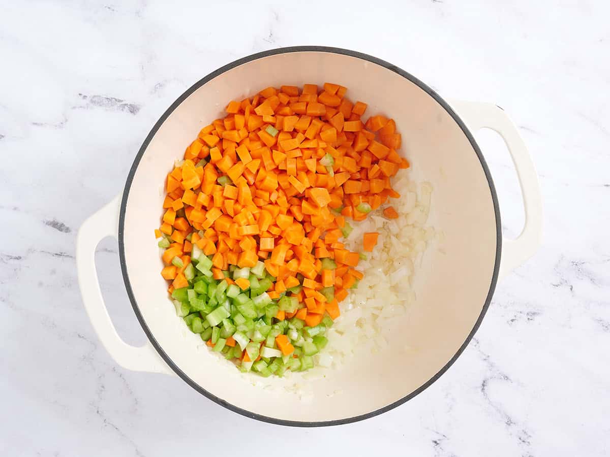 Se añaden las zanahorias y el apio a la cebolla en una sartén.