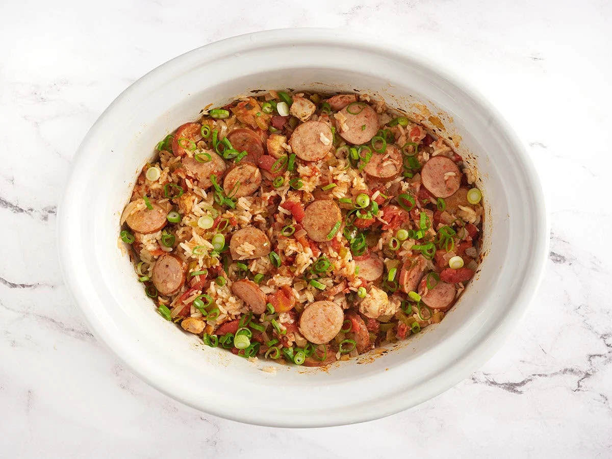 Jambalaya de cocción lenta en una olla blanca. 