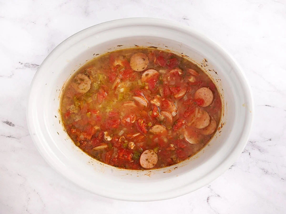 Jambalaya en olla de cocción lenta hirviendo a fuego lento en la olla de cocción lenta. 