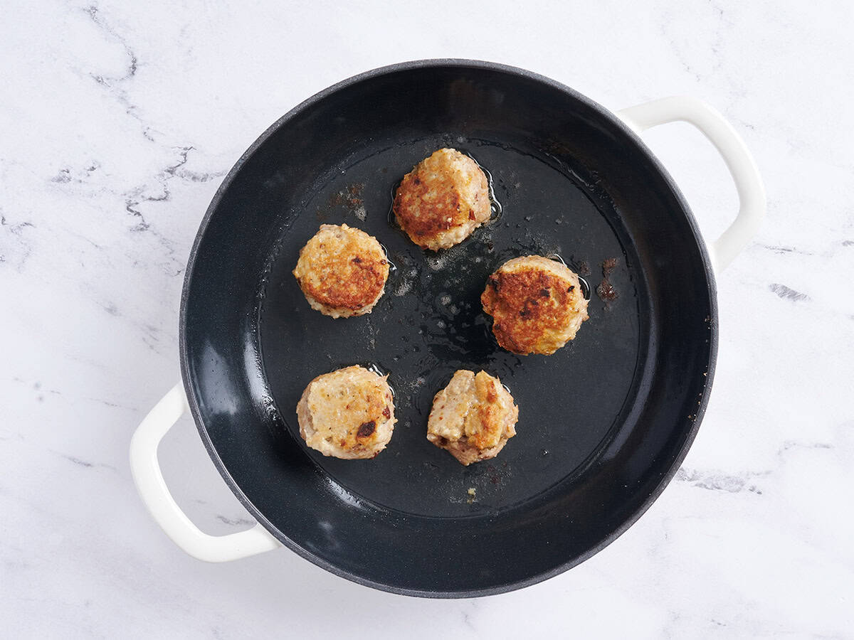 Cásate conmigo albóndigas de pollo dorándolas en una sartén.