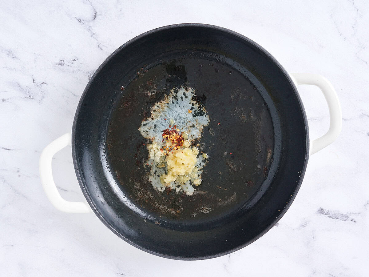 Mantequilla, ajo y hojuelas de chile en una sartén.