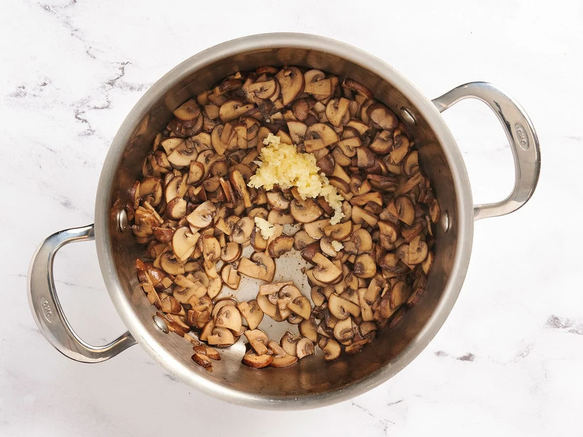 Champiñones en una sartén con ajo.