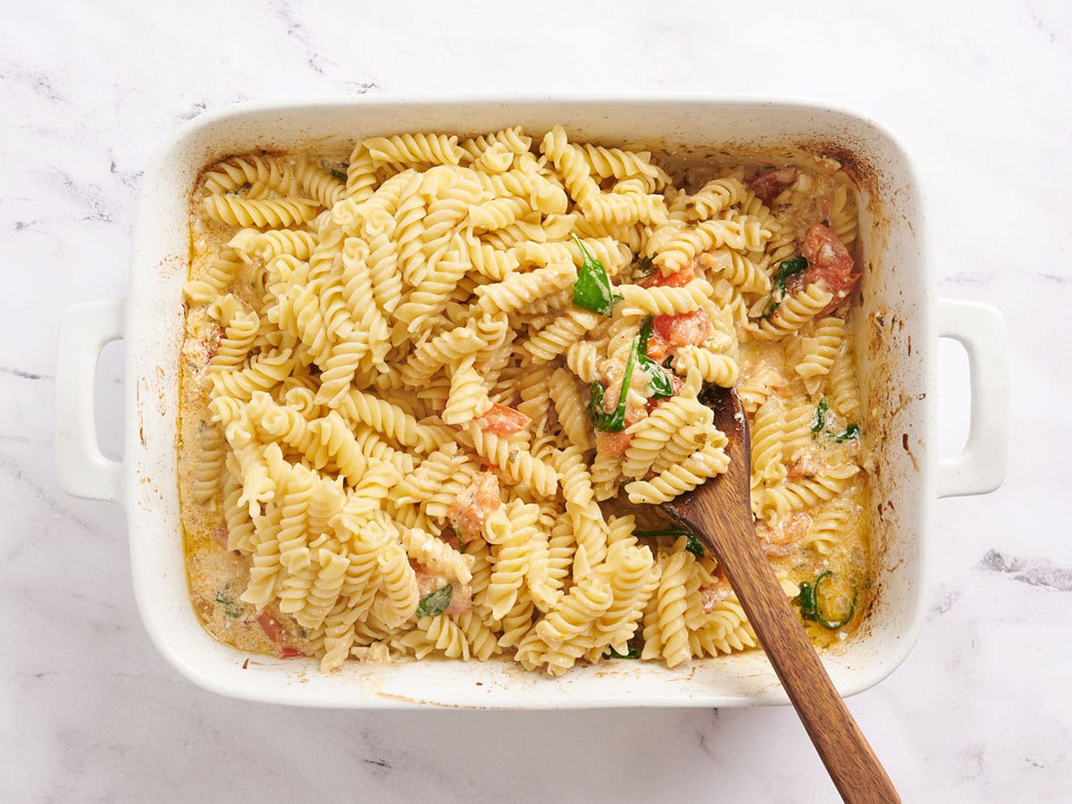 Pasta rotini mezclada con tomates asados, cebollas y queso feta.