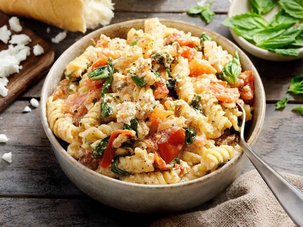 Side view of feta pasta in a bowl with a fork.