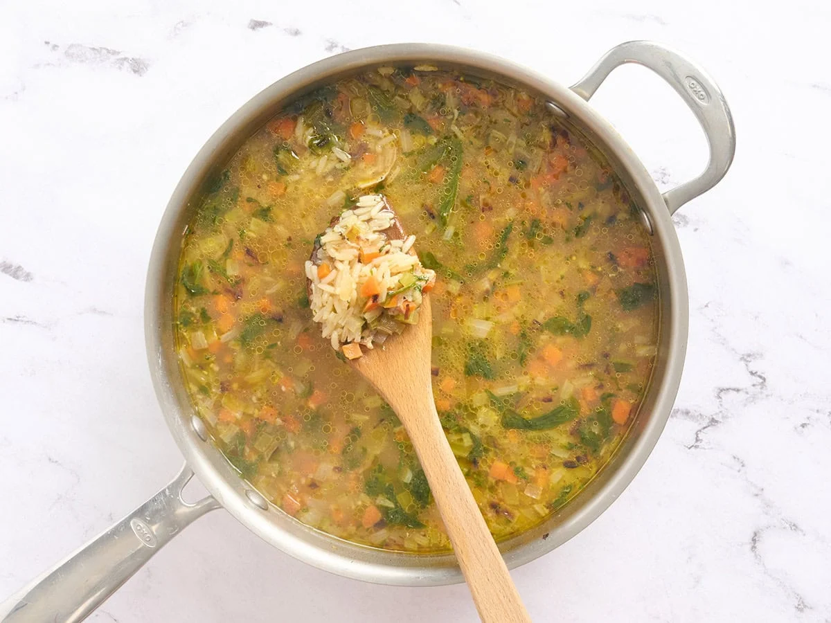 Un poco de arroz caldoso en una cuchara de madera.