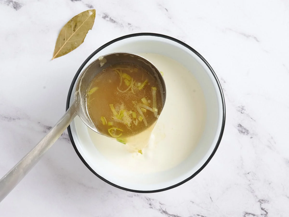 Se vierte sopa caliente en un plato de crema.