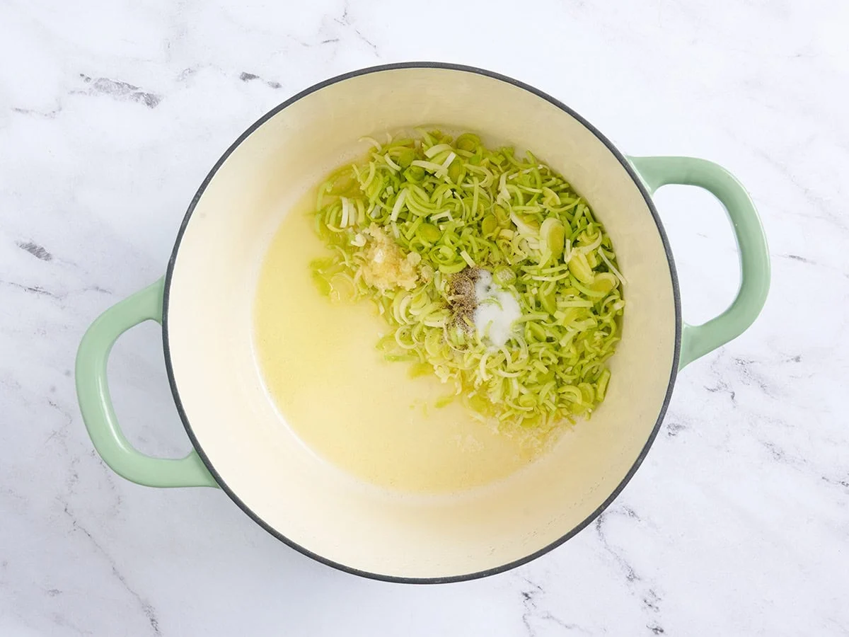 En una olla la mantequilla derretida y el aceite con los puerros y el ajo picados.