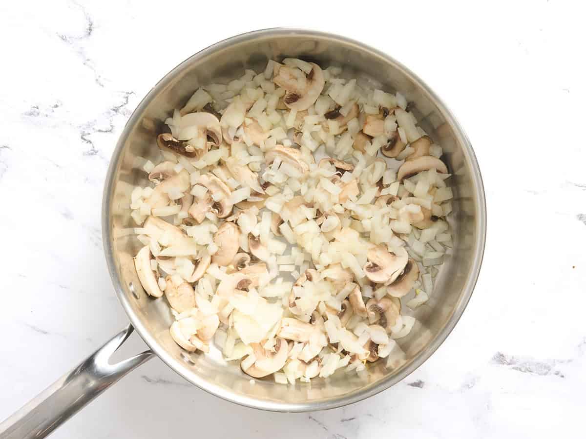 Champiñones y cebollas en una sartén.