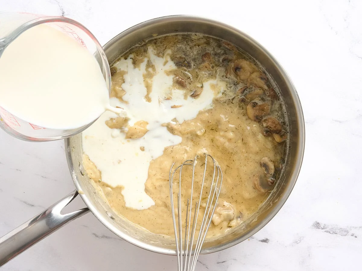 Se vierte la leche en una sartén con un roux.