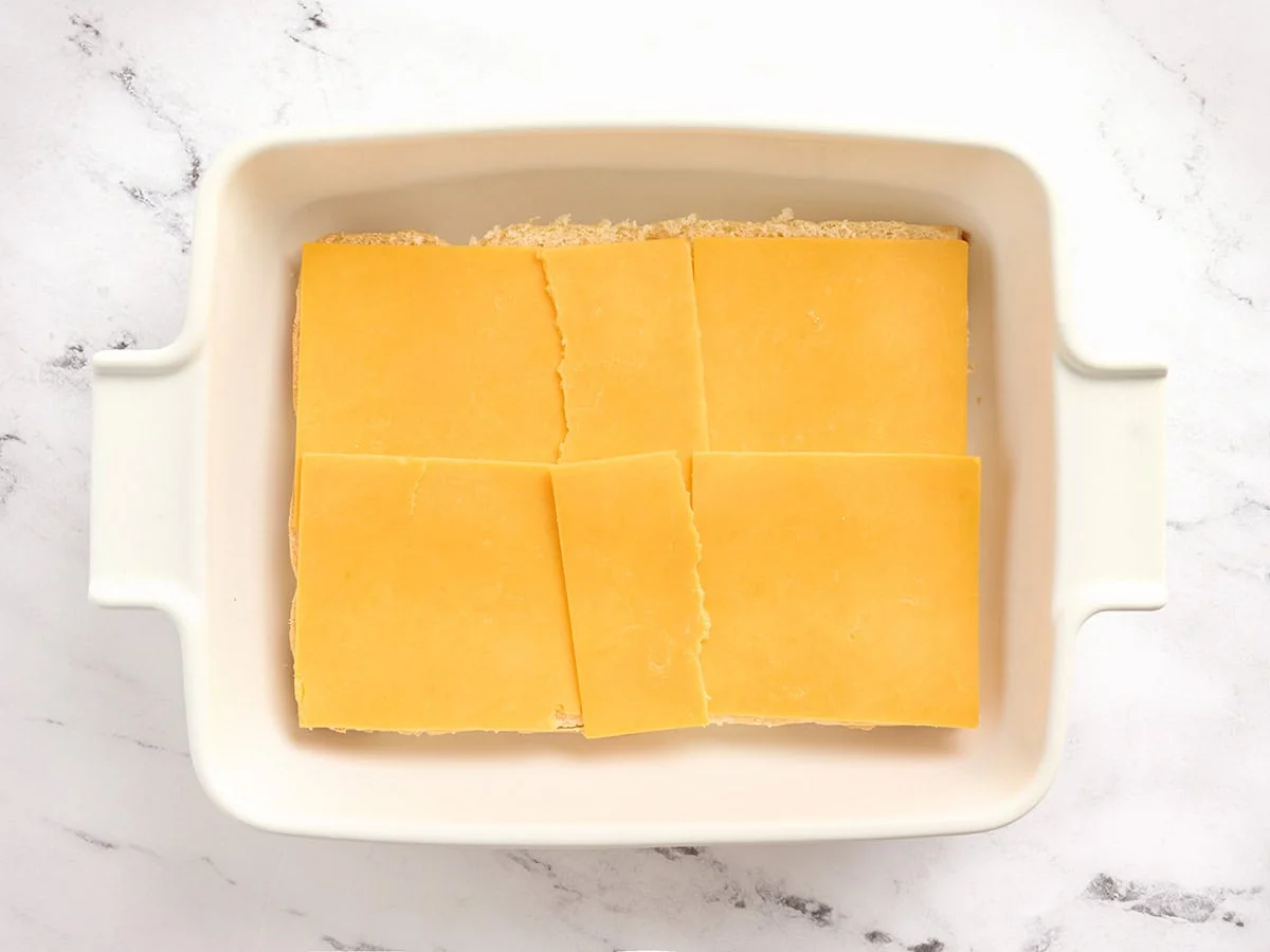 Una capa de queso americano encima de hamburguesas hawaianas en rodajas.